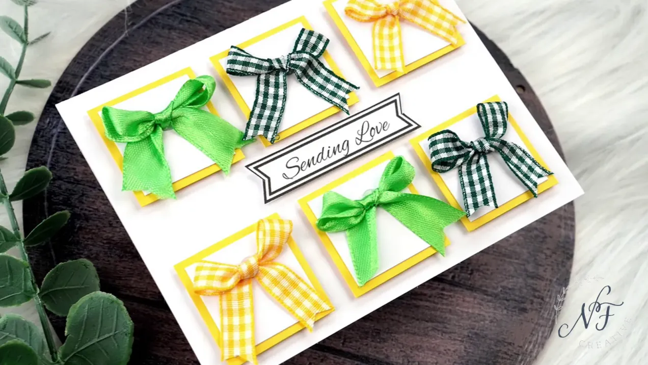 Sending love panel card with green and yellow bows set on a wooden tray with floral elements