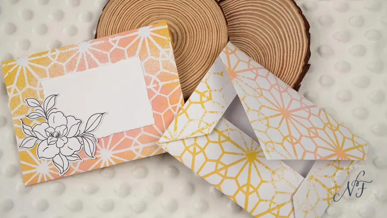 Two DIY envielopes with floral and snowflake designs flat laid on wooden stumps by Natasha Foote Creative